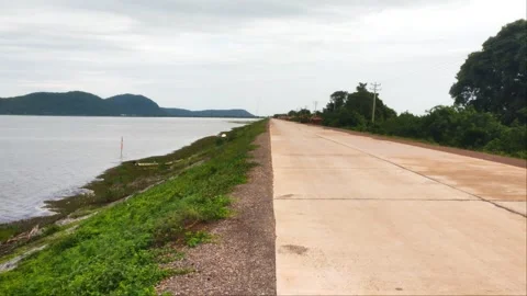 Empty Concrete Road Along Reservoir Bank with Scenic Mountain View Stock Footage 344317895