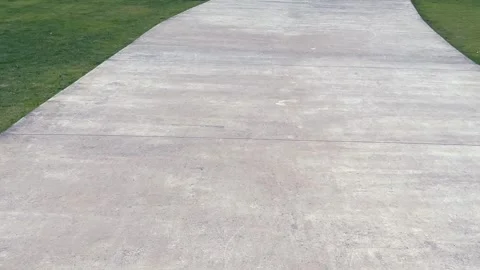 Empty concrete road surface in the public park with green grass Stock Footage 324747118