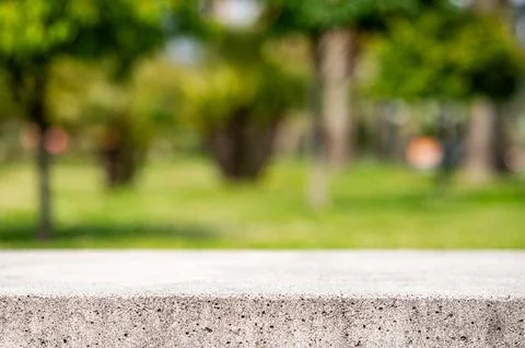 Empty concrete surface with blurred green park background and copy space Stock Photos