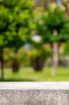 Empty concrete surface with blurred green park background and copy space Stock Photos