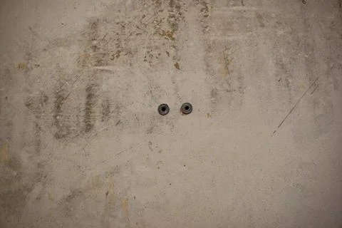 Empty concrete wall with two gray dowels. Renovation concept. Stock Photos