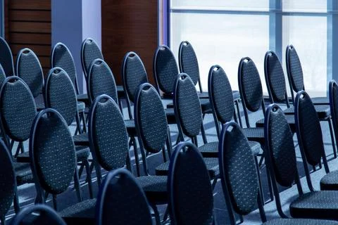 Empty conference chairs arranged in rows inside an event room Photos