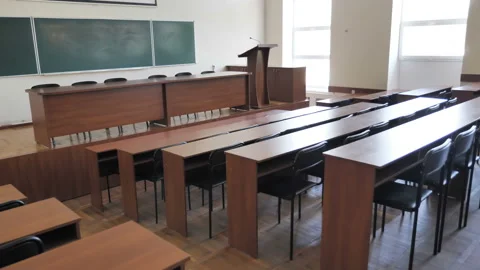 Empty conference hall, lecture hall with rows of desks, tribune for speech  Stock Footage 133495119