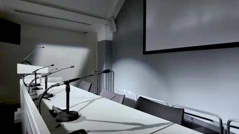 Empty Conference Hall With Microphones On White Table Presentation Screen And Stock Footage 328153050