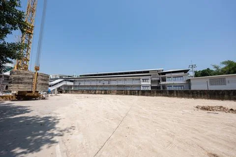 Empty construction site with cleared ground and building structure in backg.. 库存照片