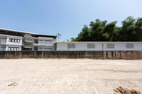 Empty construction site with cleared ground and building structure in backg.. 库存照片