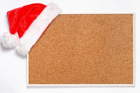 An empty cork board with a Santa hat. Making plans for the new year or a plac Stock Photos