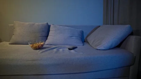 Empty Couch Illuminated by Television Light in a Quiet Nighttime Living Room Stock Footage 342352982