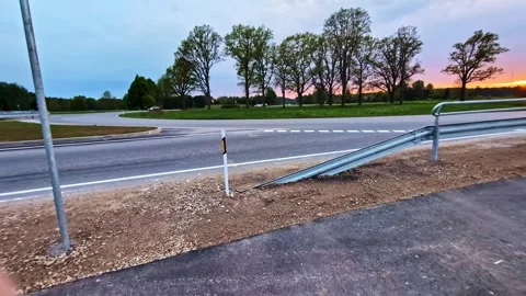 Empty country road and sidewalk curving at a scenic sunset with passing cars Stock Footage 341457407