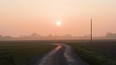 Empty country road passing through the green field at sunset Stock Footage 113009584