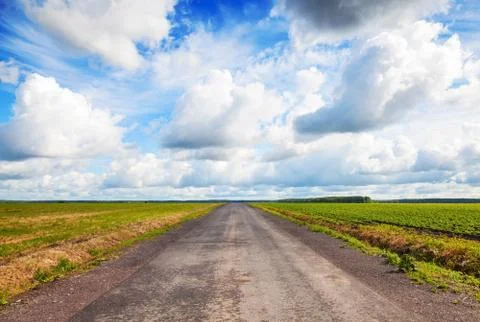Empty country road perspective with dramatic cloudy sky Stock Photos
