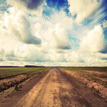 Empty country road perspective with dramatic cloudy sky. Toned effect Stock Photos