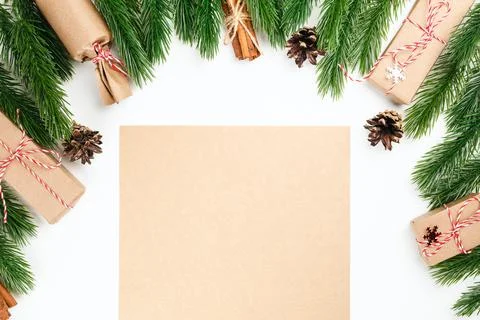 Empty craft paper in frame of Christmas pine branches, bundles of cinnamon and Stock Photos