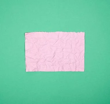 Empty crumpled pink rectangular sheet of paper on a green background Foto stock
