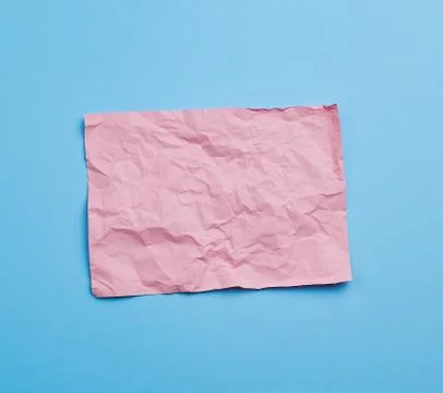 Empty crumpled pink rectangular sheet of paper a4 on a blue background Foto stock