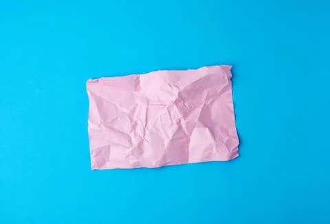 Empty crumpled pink rectangular sheet of paper a4 on a blue background Foto stock