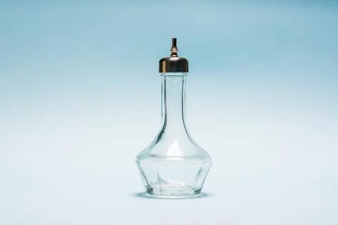 Empty crystal bitters bottle or bartender medicine bottle on blue background Stock Photos