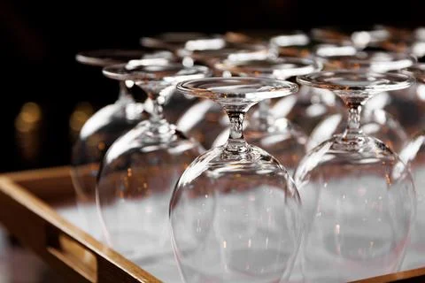 Empty crystal-clear wine glasses inverted on a wooden tray. Stock Photos