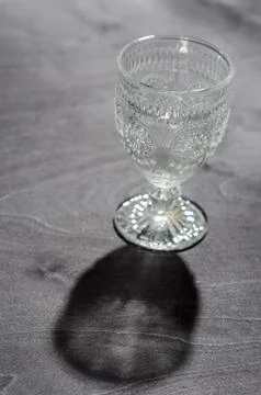 Empty crystal pancake with a pattern, on a dark wooden background Stock Photos