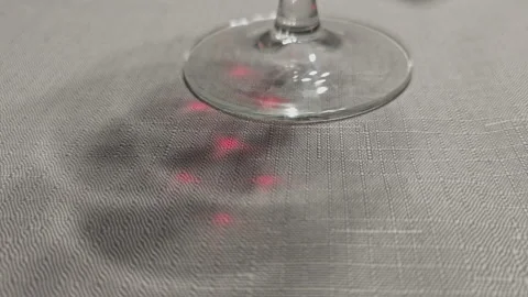 Empty crystal wine glass standing on a grey textured tablecloth. Its shadow Stock Footage 345679971