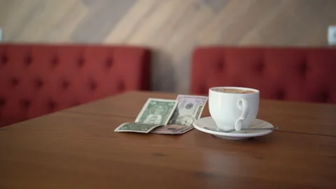 Empty cup and a fifty one dollar tip on a restaurant table. payment, tip Stock Footage 226389852