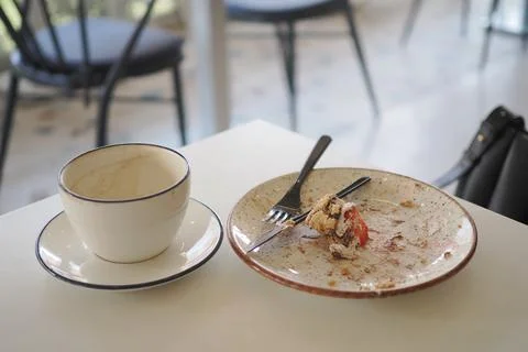 Empty cup and plate after meal in a cafe Stock Photos