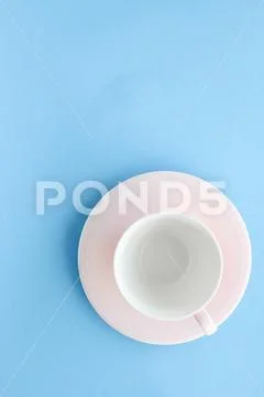 Empty cup and saucer on blue background, flatlay Stock Photos