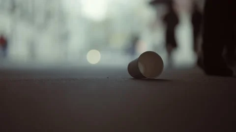 An empty cup of coffee is lying on the asphalt. urban waste problem concept Video stock 153371079