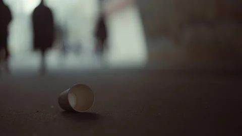 An empty cup of coffee is lying on the asphalt. urban waste problem concept Stock Footage 153371287