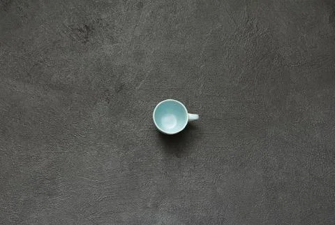 Empty cup poverty blue black stone background Stock Photos
