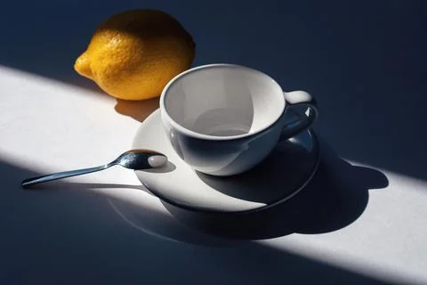 Empty cup for tea or coffee with lemon, morning light and shadow Stock-Fotos