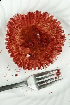 Empty cupcake wrapper, crumbs and a fork Stock Photos