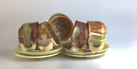 Empty cups made of multi-colored onyx in yellow-orange tones on a white bac.. Stock Photos