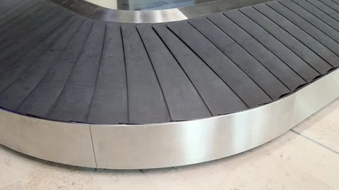 An empty curved baggage carousel rotates continuously at the airport terminal Video stock 345166241