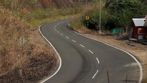 Empty Curved Countryside Road With Small Roadside Hut Video stock 329839724