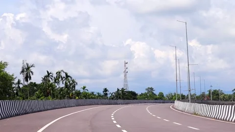 Empty Curved Road with Modern Streetlights and Tropical Landscape Stock Footage 346240591