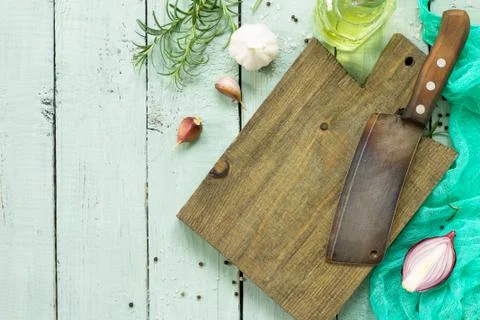 Empty cutting board and old knives on a wooden culinary background. Stock Photos