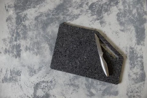 Empty cutting granite board on concrete gray background with alumene, silver, Foto stock
