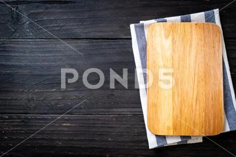 Empty cutting wooden board with kitchen cloth Stock Photos