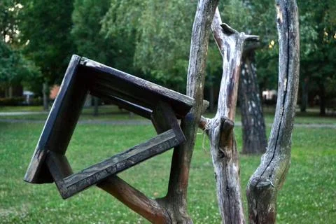 Empty damaged bird feeder on a withered tree in a public park Stock Illustration