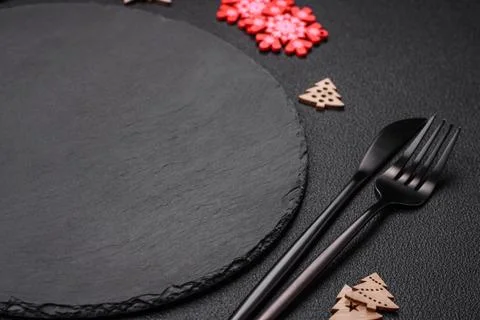 Empty dark ceramic plate with elements of Christmas decorations Fotos Stock