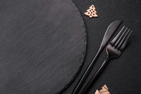 Empty dark ceramic plate with elements of Christmas decorations 스톡 사진