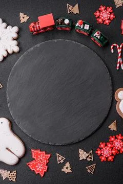 Empty dark ceramic plate with elements of Christmas decorations Fotos Stock