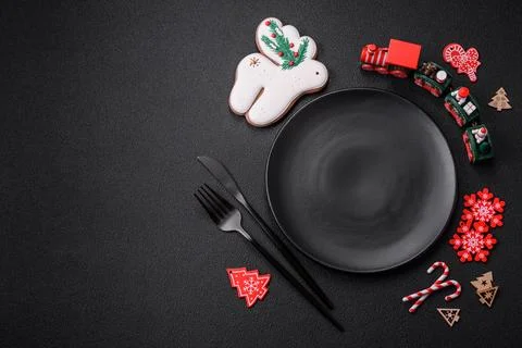 Empty dark ceramic plate with elements of Christmas decorations Foto stock