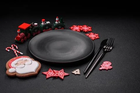 Empty dark ceramic plate with elements of Christmas decorations Foto stock