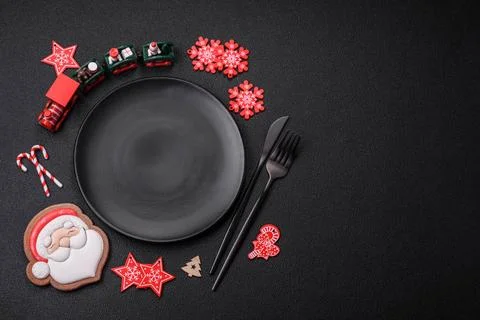 Empty dark ceramic plate with elements of Christmas decorations Empty dark... Stock Photos