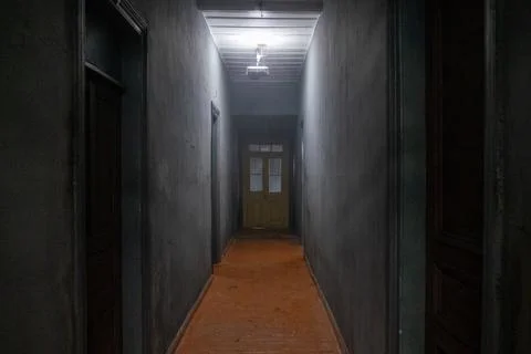 Empty Dark Corridor Leading to Closed Door Foto stock