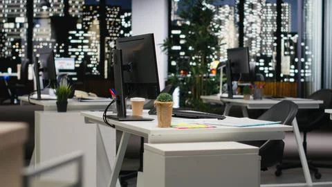 Empty dark office features high tech gadgets and dual monitors Stock Photos