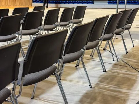 Empty dark performance chairs lined up inside an arena scene Stock Photos