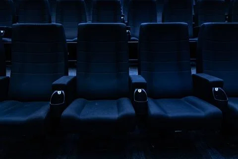 Empty dark rows of blue cinema seats in auditorium 스톡 사진